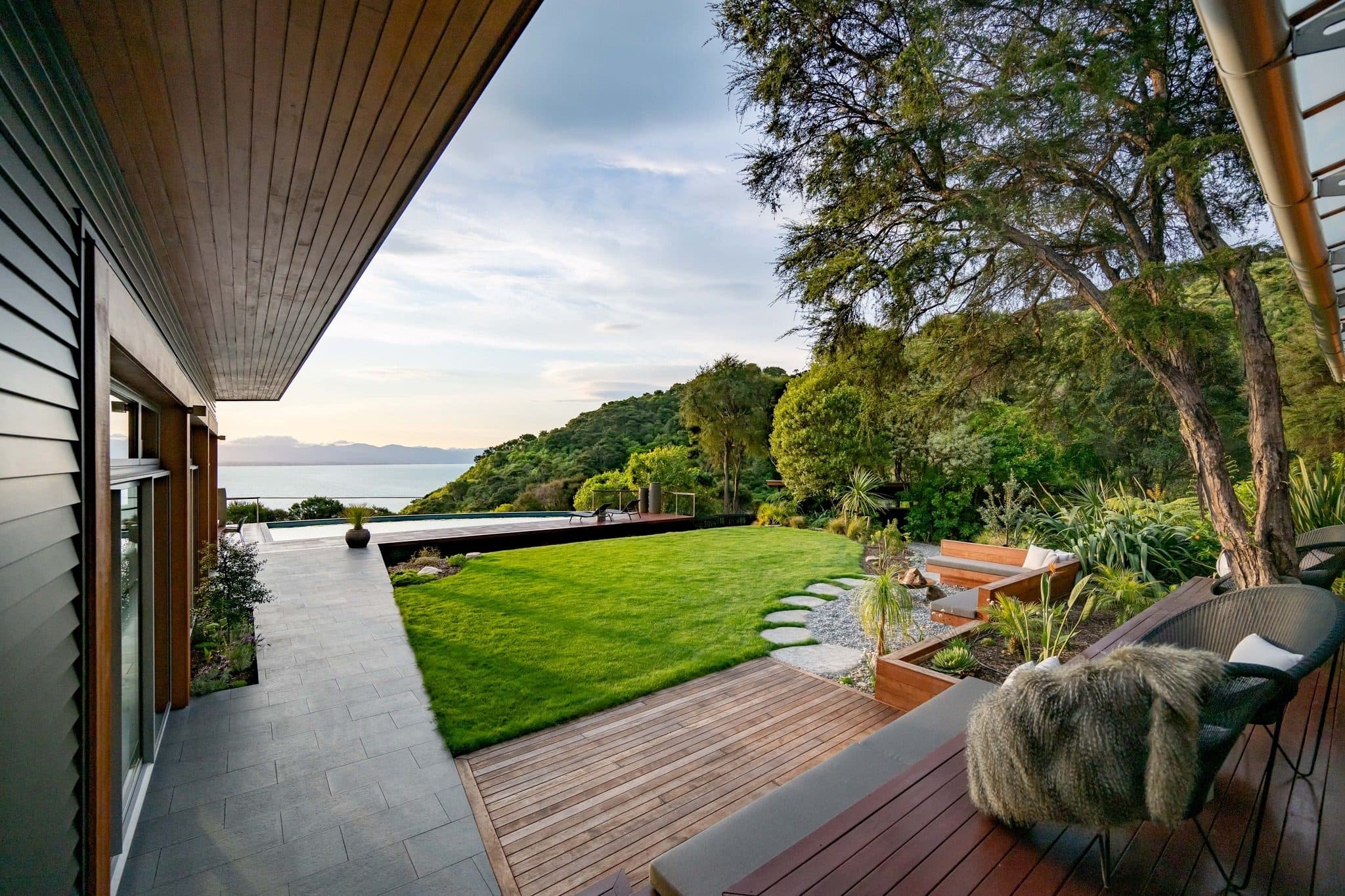 The terrace and lawn at Okoro Villa, looking out to the water